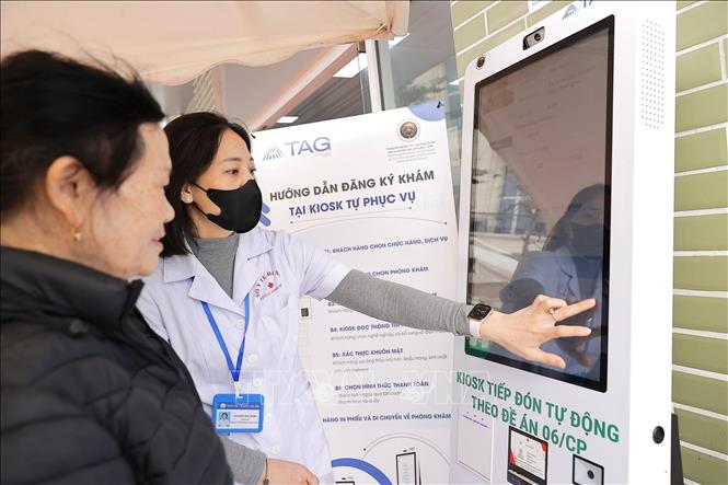 Nhân viên y tế phường Bồ Đề hướng dẫn người dân đăng ký khám bằng thẻ CCCD. Ảnh: Minh Quyết - TTXVN 