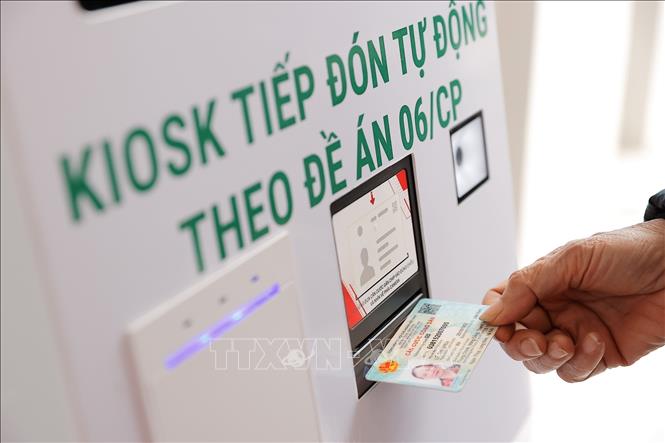 Nhân viên y tế phường Bồ Đề hướng dẫn người dân đăng ký khám bằng thẻ CCCD. Ảnh: Minh Quyết - TTXVN 