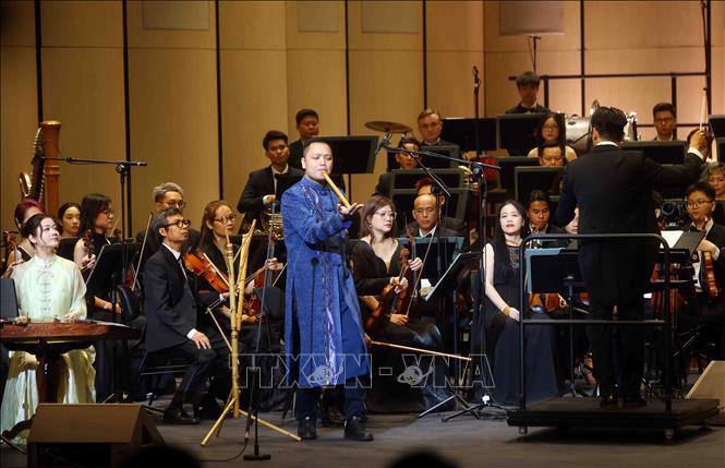 Chương trình nghệ thuật với sự kết hợp giữa các nghệ sĩ biểu diễn nhạc cụ dân tộc và Dàn nhạc giao hưởng Hà Nội. Ảnh: Phạm Kiên - TTXVN