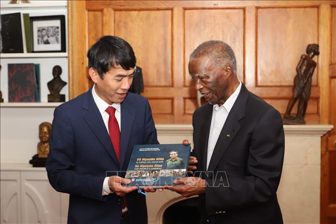 Đại sứ Hoàng Sỹ Cường trao tận tay cựu Tổng thống Nam Phi Thabo Mbeki cuốn sách “Võ Nguyên Giáp - vị tướng của nhân dân” song ngữ Việt-Anh, do con trai Đại tướng, ông Võ Hồng Nam, đề tặng. Ảnh: Hồng Minh - PV TTXVN tại Nam Phi