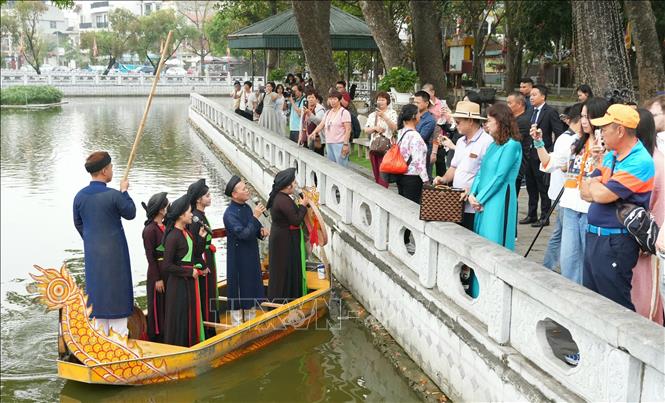 Du khách nghe hát quan họ trên thuyền tại Đền Đô. Ảnh: Đồng Thúy - TTXVN