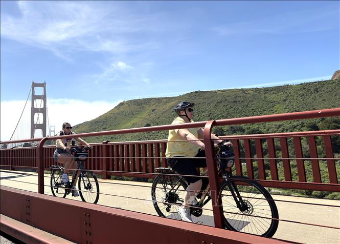 Du khách đạp xe trên cầu Cổng Vàng. Ảnh: Ngọc Quang – PV TTXVN tại Mỹ