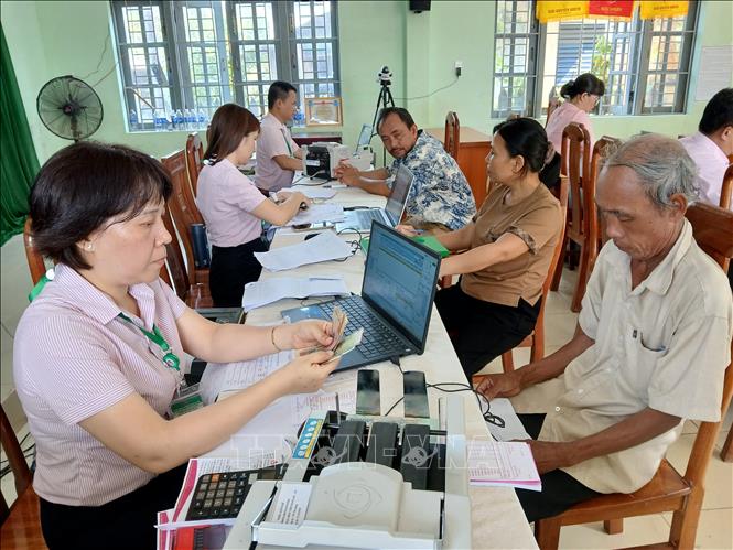 Phòng Giao dịch Ngân hành chính sách xã hội Hội An phối hợp với các hội, đoàn thể giải ngân vốn đến đối tượng hưởng thụ. Ảnh: Mỹ Hà - TTXVN