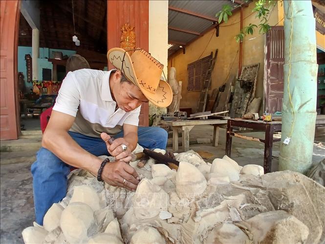 Anh Phan Huỳnh Châu ở Tổ dân phố Phước Trung, phường Hội An (Đà Nẵng) được hỗ trợ vay vốn phát triển sản xuất kinh doanh điêu khắc gỗ. Ảnh: Mỹ Hà - TTXVN