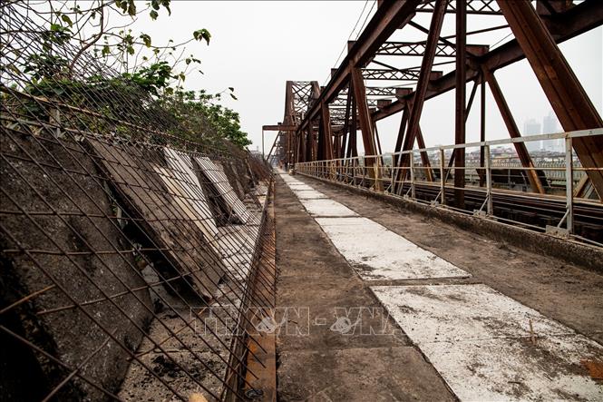 Sau khi hoàn tất xử lý nền, lớp nhựa mới sẽ được thảm trên phần đường bộ, tạo bề mặt bằng phẳng, an toàn khi lưu thông trên cầu Long Biên. Ảnh: Vân Chi/TTXVN phát
