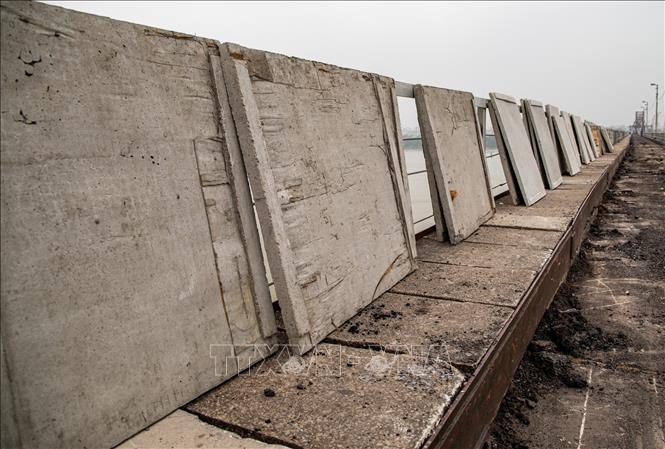 Các tấm đan bê tông mác 400 sẽ được sử dụng nhằm tạo bề mặt phẳng, tăng khả năng chịu lực, thay thế các đoạn mặt cầu hư hỏng. Loại bê tông cường độ cao này giúp giảm nguy cơ nứt vỡ khi có tải trọng lớn; đồng thời, các máng thoát nước bằng thép cũng được thay thế. Ảnh: Vân Chi/TTXVN phát