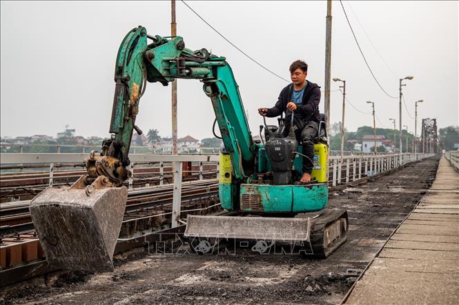 Công nhân cùng máy móc, vật liệu chuyên dụng được huy động, khẩn trương thi công các hạng mục sửa chữa trên Cầu Long Biên nhằm đảm bảo tiến độ đề ra. Ảnh: Vân Chi/TTXVN phát
