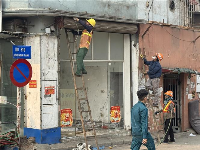 Người dân đồng thuận di dời hoàn trả mặt bằng cho dự án với sự hỗ trợ của lực lượng chức năng tại ngõ 310 đường Nghi Tàm. Ảnh: Quốc Lũy - TTXVN