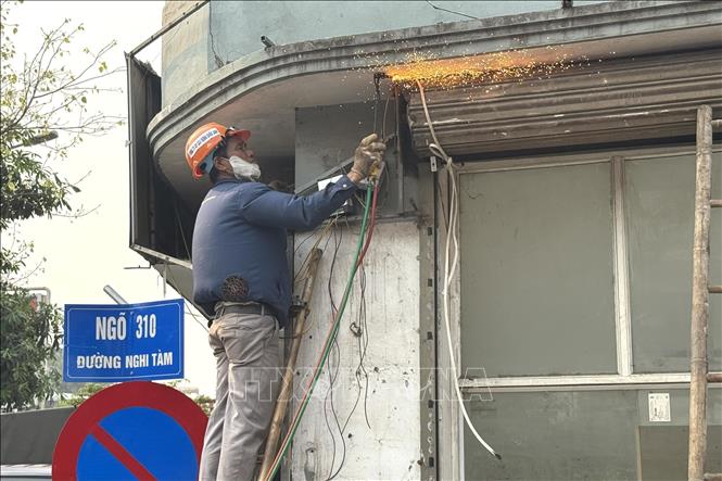 Người dân đồng thuận di dời hoàn trả mặt bằng cho dự án với sự hỗ trợ của lực lượng chức năng tại ngõ 310 đường Nghi Tàm. Ảnh: Quốc Lũy - TTXVN