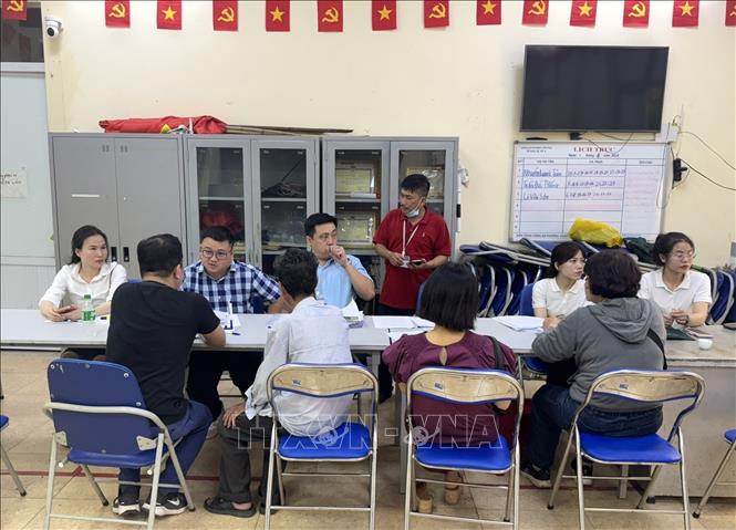 Cán bộ phường Hồng Hà tư vấn giả thích cho người dân đến nhận tiền đền bù giải phóng mặt bằng. Ảnh: Quốc Lũy - TTXVN