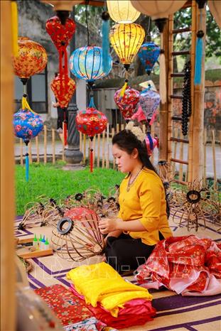 Nghệ nhân làm trực tiếp làm các sản phẩm lồng đèn. Ảnh: Khánh Hoà - TTXVN