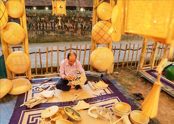 Nghệ nhân làm trực tiếp làm các sản phẩm lồng đèn. Ảnh: Khánh Hoà - TTXVN