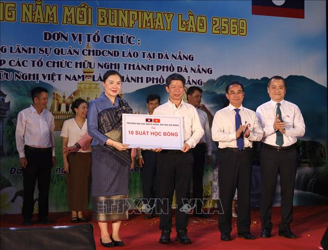 Đại diện các trường Đại học tại Đà Nẵng trao bảng tượng trưng tặng các suất học bổng hỗ trợ sinh viên Lào học tập tại thành phố cho Tổng Lãnh sự quán Lào tại Đà Nẵng. Ảnh: Trần Lê Lâm - TTXVN 