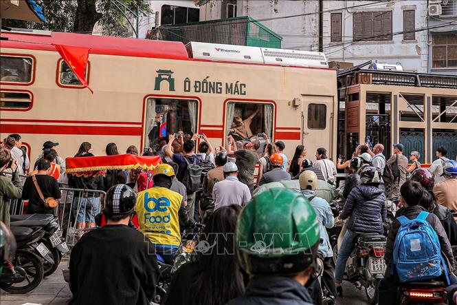 Du khách ghi lại khoảnh khắc “Tàu 5 cửa ô” đi qua phố cổ, cho thấy sức hút của loại hình du lịch trải nghiệm gắn với không gian đô thị di sản. Ảnh: Phạm Tuấn Anh - TTXVN
