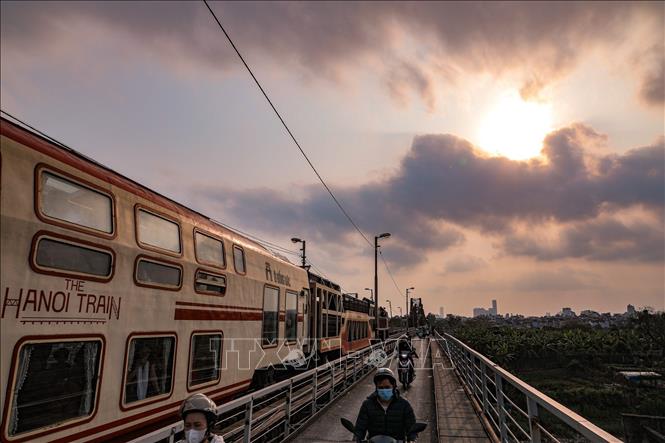 “Tàu 5 cửa ô” lăn bánh trong ánh hoàng hôn trên cầu Long Biên, hành trình trải nghiệm không gian văn hóa – lịch sử Hà Nội từ góc nhìn mới, kết nối quá khứ với nhịp sống hiện đại của Thủ đô. Ảnh: Phạm Tuấn Anh - TTXVN