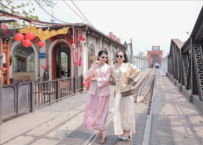 Du khách trong trang phục truyền thống lưu lại khoảnh khắc bên khu vực cầu Long Biên – điểm nhấn trong hành trình trải nghiệm văn hóa Hà Nội trên “Tàu 5 cửa ô”. Ảnh: Phan Phương - TTXVN