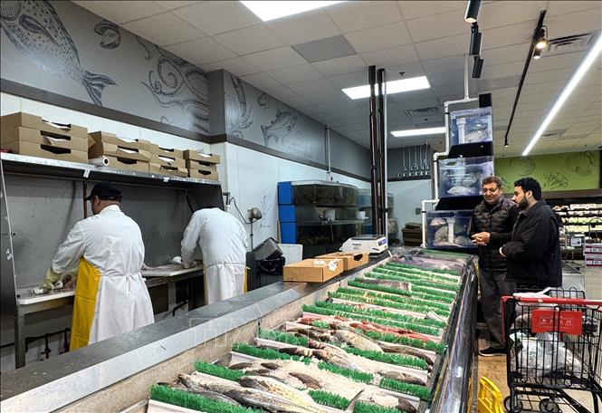 Các nhân viên sơ chế hải sản cho khách hàng tại siêu thị Great Wall ở bang Virgninia. Ảnh: Đoàn Hùng-P/v TTXVN tại Mỹ