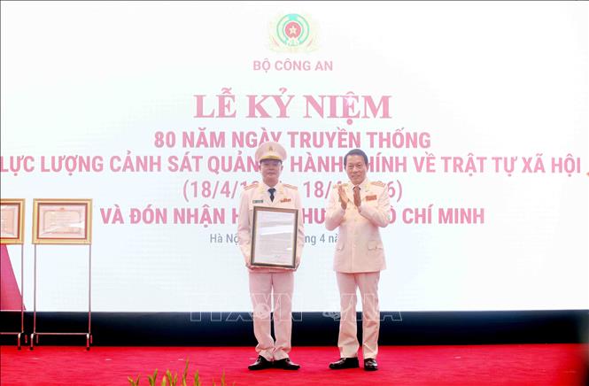 Đại tướng Lương Tam Quang, Ủy viên Bộ Chính trị, Bí thư Đảng ủy Công an Trung ương, Bộ trưởng Bộ Công an trao Thư chúc mừng của Tổng Bí thư, Chủ tịch nước Tô Lâm cho lực lượng Cảnh sát Quản lý hành chính về trật tự xã hội. Ảnh: Phạm Kiên - TTXVN