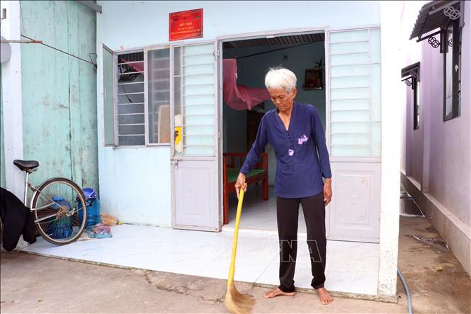 Bà Lý Sươl (khu vực Đại Nghĩa Thắng, phường Mỹ Xuyên) bên căn nhà mới được Nhà nước hỗ trợ kinh phí xây dựng, giúp gia đình chấm dứt cảnh sống trong nhà tạm bợ. Ảnh: Trung Kiên - TTXVN