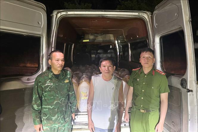 1.500 lít xăng được vận chuyển trên xe ô tô tải van để chia nhỏ, vận chuyển qua Lào bằng xe máy. Ảnh: TTXVN phát