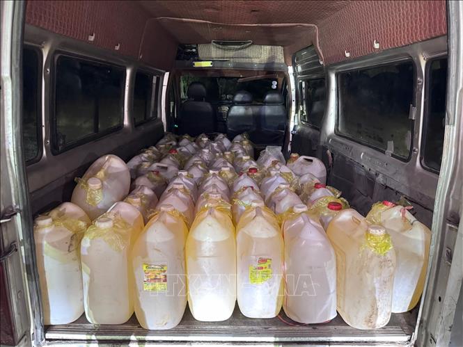 1.500 lít xăng được vận chuyển trên xe ô tô tải van để chia nhỏ, vận chuyển qua Lào bằng xe máy. Ảnh: TTXVN phát