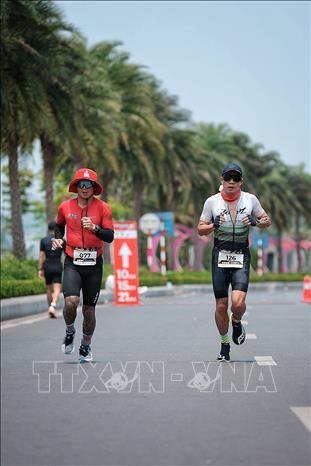 Các vận động viên duy trì nhịp độ ổn định trên chặng chạy bộ của giải triathlon, vượt qua quãng đường dài trong điều kiện thời tiết oi bức. Ảnh: Phạm Tuấn Anh - TTXVN