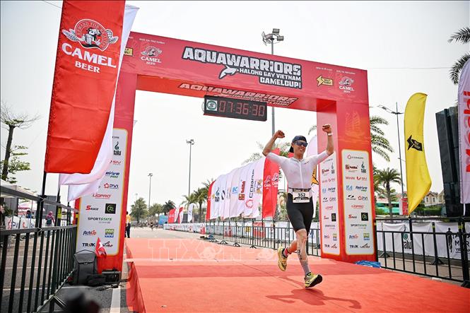 Vận động viên hoàn thành mục tiêu 3 môn phối hợp: Bơi, đạp xe, chạy điền kinh. Ảnh: Phạm Tuấn Anh - TTXVN
