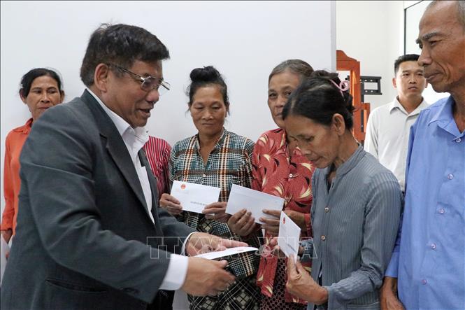 Thứ trưởng Bộ Dân tộc và Tôn giáo Y Thông trao quà cho các hộ có hoàn cảnh khó khăn tại xã Hồ Đắc Kiện. Ảnh: Trung Kiên - TTXVN