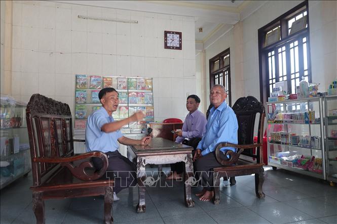 Ông Võ Văn Kèn (bên phải)-người gần 50 năm gắn bó với cộng đồng dân vạn đò kể những câu chuyện mưu sinh. Ảnh: Hải Âu-TTXVN.