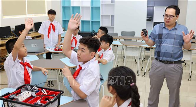 Phần thảo luận về sự khác biệt giữa hình ảnh do AI tạo ra và hình ảnh thực tế giúp học sinh nâng cao nhận thức về tính chân thực, đồng thời hiểu rõ hơn về các nguyên tắc đạo đức khi sử dụng công nghệ trong môi trường số. Ảnh: Thanh Tùng - TTXVN 