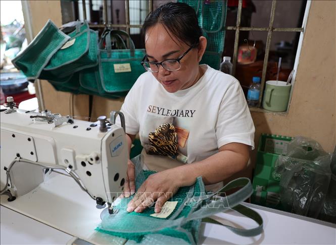 Bà Trần Thị Mỹ, ngụ xã Long Sơn, có thu nhập ổn định khoảng 200.000 đồng/ngày nhờ làm túi lưới. Ảnh: Hoàng Nhị – TTXVN