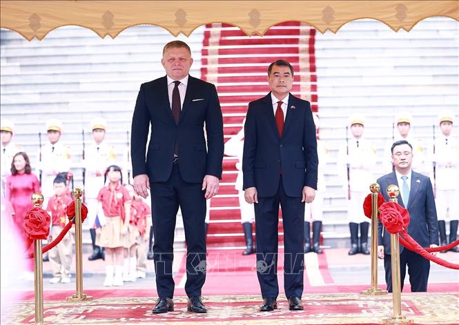 Thủ tướng Lê Minh Hưng và Thủ tướng Slovakia Robert Fico nghe Quân nhạc cử Quốc thiều hai nước. Ảnh: Dương Giang - TTXVN 