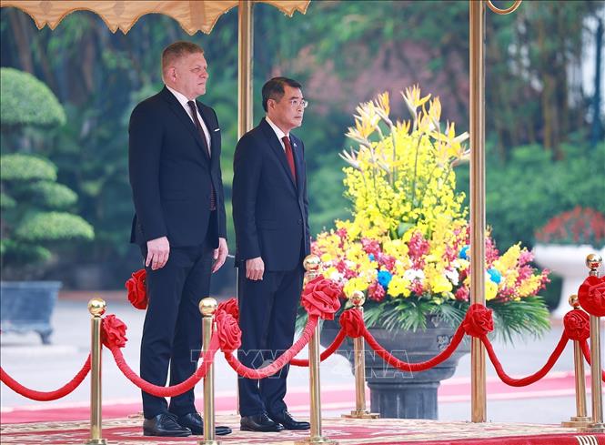 Thủ tướng Lê Minh Hưng và Thủ tướng Slovakia Robert Fico nghe Quân nhạc cử Quốc thiều hai nước. Ảnh: Dương Giang - TTXVN 