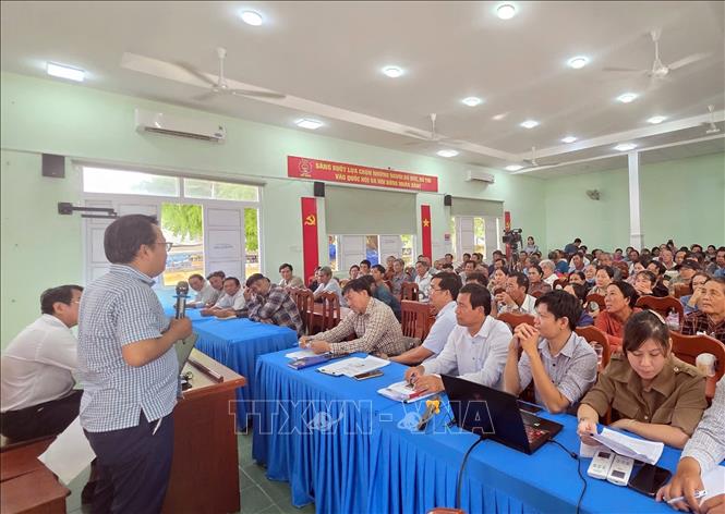 Lãnh đạo UBND xã Phước Dinh thông tin chi trả kinh phí hỗ trợ cho thân nhân di dời mộ để thi công dự án Nhà máy điện hạt nhân Ninh Thuận 1. Ảnh: TTXVN phát