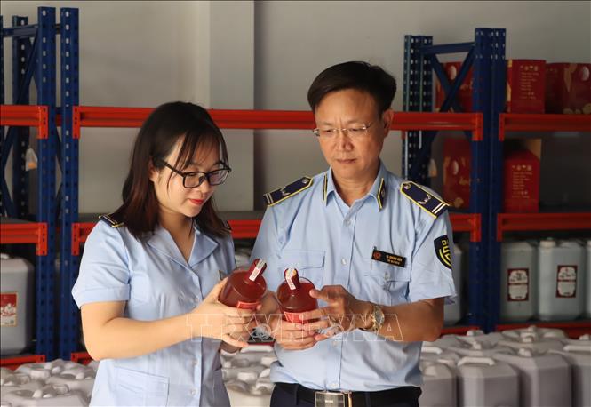 Lực lượng chức năng kiểm tra rượu không rõ nguồn gốc. Ảnh: TTXVN phát