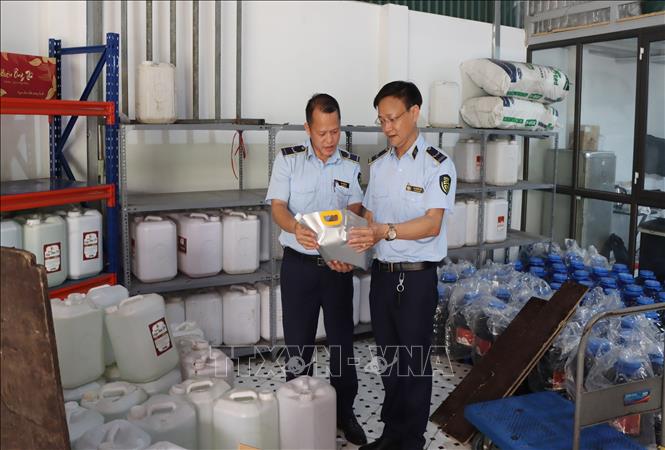 Lực lượng chức năng kiểm tra rượu không rõ nguồn gốc. Ảnh: TTXVN phát
