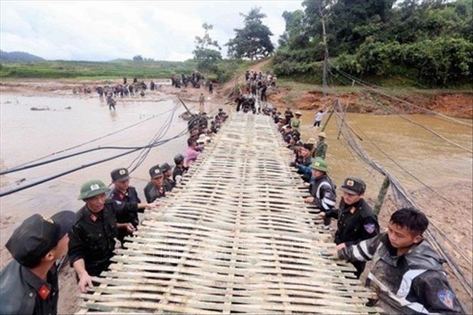 Cán bộ, chiến sỹ Cảnh sát Cơ động làm cầu tạm vượt suối giúp nhân dân bản Nà Cà, xã Mường Chanh, huyện Mai Sơn, Sơn La. Ảnh: Quang Quyết - TTXVN