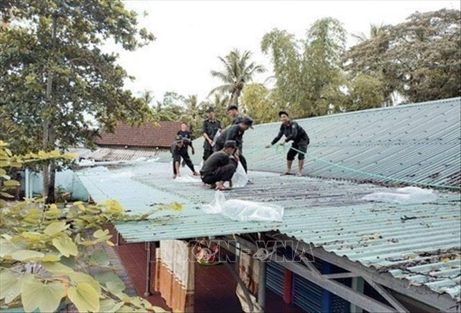 Cán bộ, chiến sĩ thuộc Tiểu đoàn Cảnh sát đặc nhiệm số 3 (Bộ Tư lệnh CSCĐ) giúp người dân chuyển bao cát đặt lên mái nhà nhằm gia cố chỗ ở phòng, chống siêu bão Noru tại thành phố Đà Nẵng. Ảnh: TTXVN phát