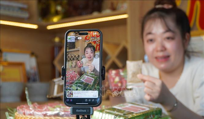 Nhân viên Cơ sở sản xuất nem Hoàng Khánh livestream giới thiệu và bán hàng trên nền tảng Tiktok shop. Ảnh: Nhựt An - TTXVN