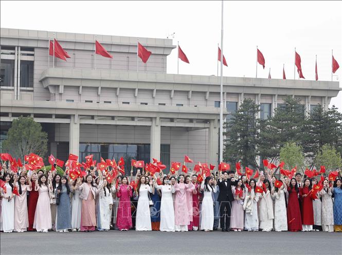 Overseas Vietnamese and students meet Party General Secretary and State President To Lam and his spouse at the Beijing International Airport. VNA Photo: Thống Nhất 