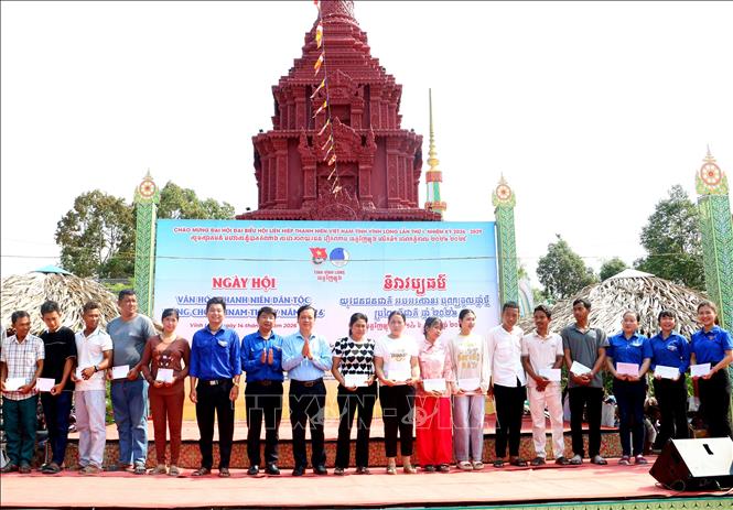 Tặng quà cho các hộ gia đình, thanh niên dân tộc có hoàn cảnh khó khăn. Ảnh: Lê Thúy Hằng – TTXVN