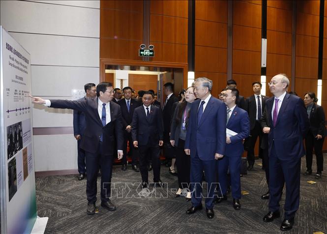 Tổng Bí thư, Chủ tịch nước Tô Lâm và đại biểu nghe giới thiệu về Đại học Thanh Hoa. Ảnh: Thống Nhất - TTXVN