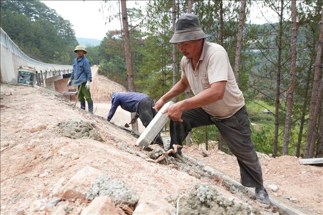 Thi công hoàn thiện phía đường dẫn ở hai đầu cầu cạn Xuân Hương trước ngày thông xe. Ảnh: Nguyễn Dũng – TTXVN