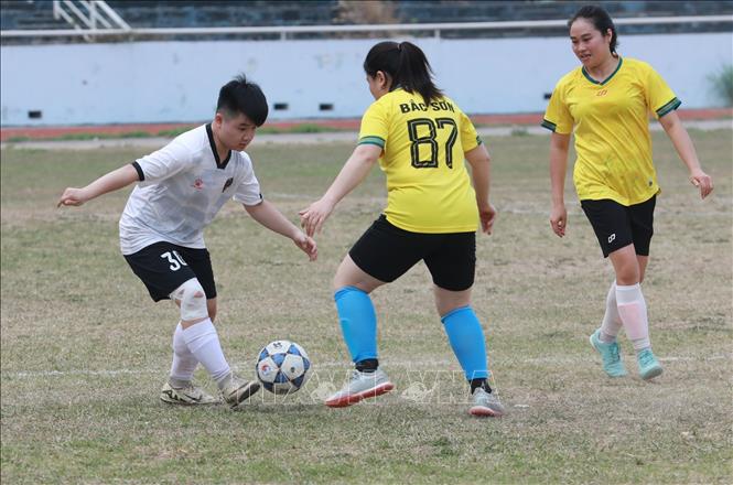 Cầu thủ đội nữ cụm xã Lộc Bình (áo trắng) tìm cách đi bóng qua cầu thủ đội nữ cụm xã Bắc Sơn (áo vàng) trong trận khai mạc Giải. Ảnh: Anh Tuấn – TTXVN