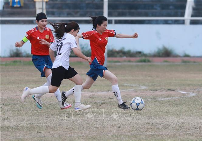 Cầu thủ đội nữ Công an tỉnh Lạng Sơn (áo đỏ) thoát khỏi sự sự đeo bám của các cầu thủ nữ cụm xã Thất Khê (áo trắng) dốc bóng về phía khung thành đối phương. Ảnh: Anh Tuấn – TTXVN