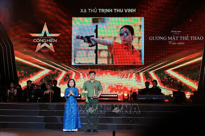 Phó Tổng Giám đốc TTXVN Đoàn Thị Tuyết Nhung trao giải hạng mục Gương mặt thể thao của năm cho VĐV bắn súng Trịnh Thu Vinh. Ảnh: Hoàng Hiếu - TTXVN
