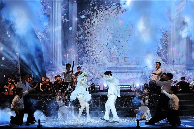 Ca sĩ ERIK trình diễn ca khúc “Dù cho tận thế vẫn yêu em” tại Lễ trao Giải thưởng Cống hiến 2026. Ảnh: Lê Đông - TTXVN