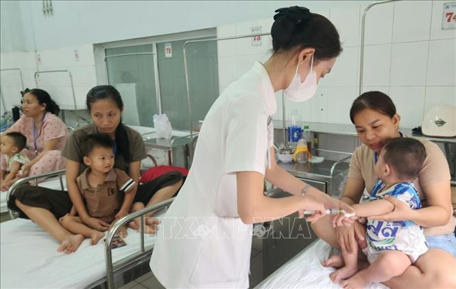 Điều trị bệnh tay chân miệng tại Trung tâm Nhi khoa, Bệnh viện Trung ương Huế. Ảnh: Mai Trang - TTXVN