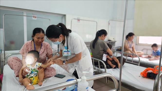 Bác sĩ thăm khám cho bệnh nhi đang điều trị bệnh tay chân miệng tại Trung tâm Nhi khoa, Bệnh viện Trung ương Huế. Ảnh: Mai Trang - TTXVN