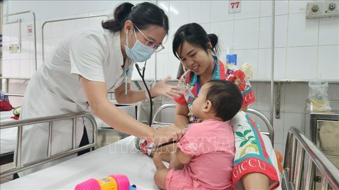 Bác sĩ thăm khám cho bệnh nhi đang điều trị bệnh tay chân miệng tại Trung tâm Nhi khoa, Bệnh viện Trung ương Huế. Ảnh: Mai Trang - TTXVN